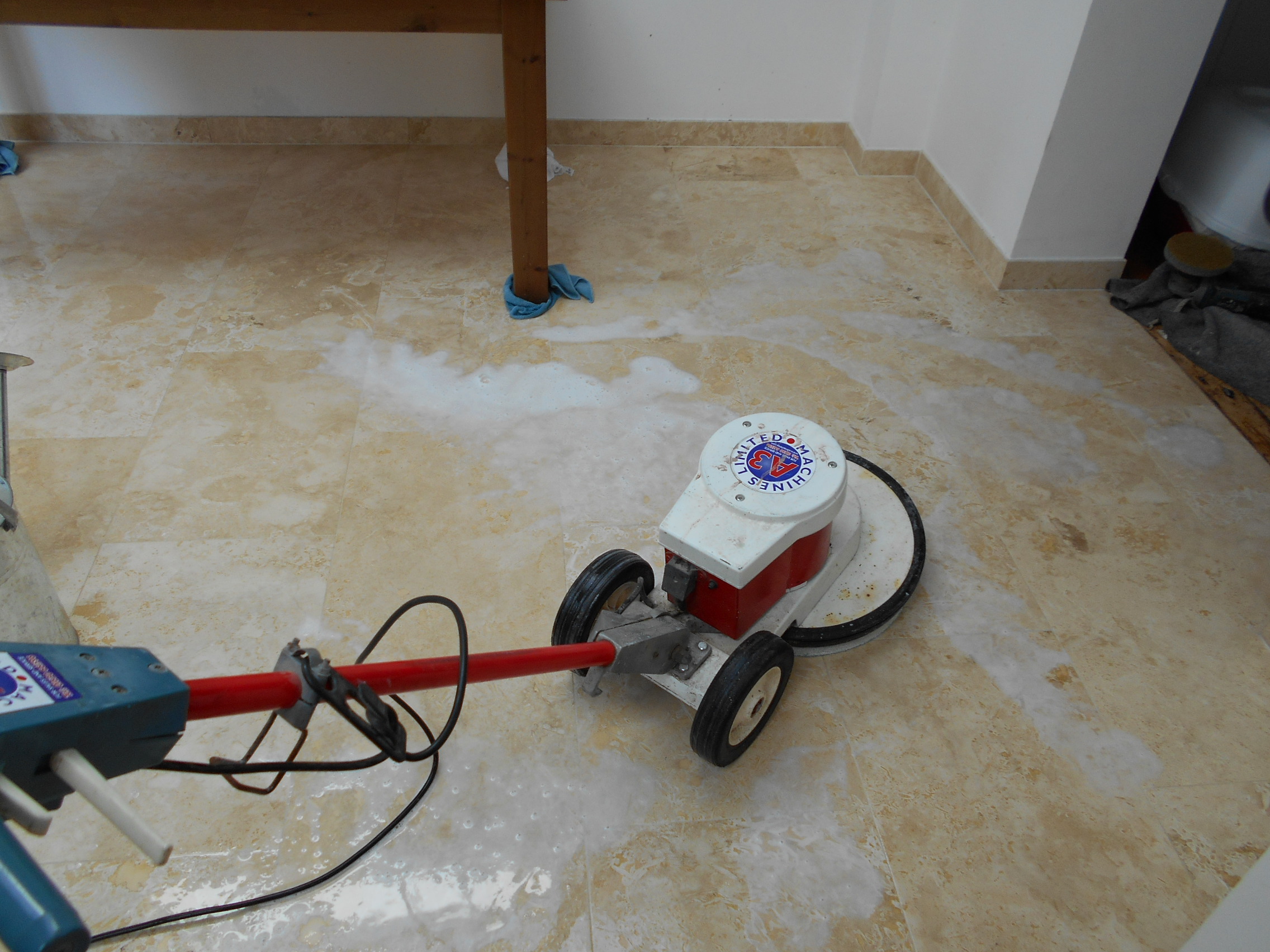 Stone tiles being polished by rotary machine